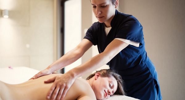 female therapist performs massage on female client