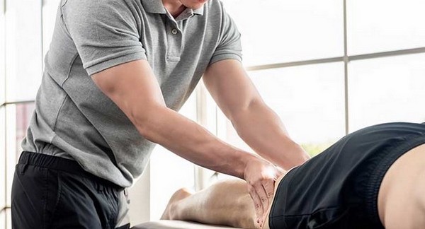 male massage therapist performs deep tissue massage